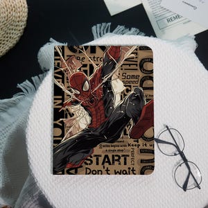 Peut inclure: Un carnet rectangulaire présentant une illustration graphique de Spider-Man en rouge et noir dans une pose dynamique. Le fond est en papier beige avec du texte imprimé en noir, incluant des phrases comme Start, Don't wait et Keep it up.