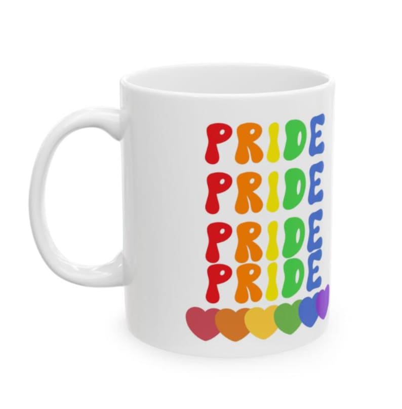 Puede incluir: Taza de cer&aacute;mica blanca con la palabra "PRIDE" en un arco&iacute;ris de colores repetida cinco veces. La palabra est&aacute; en una fuente en negrita y redondeada. En la parte inferior hay seis corazones coloridos. La taza tiene un asa blanca.