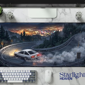 May include: A rectangular desk mat featuring a wide-angle illustration of a white sports car drifting on a winding mountain road at night. The scene includes dense pine trees, a glowing city skyline in the distance, and thick tire smoke.