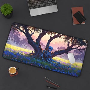 May include: A rectangular mouse mat with a colourful illustration of a skeleton resting against a tree in a field of flowers. The artwork depicts a dreamy landscape with a sunset. A white mouse is positioned on the right side of the mat.