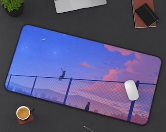 May include: A rectangular mousepad featuring a scenic illustration of a person sitting on a fence, reaching towards a starry sky with a crescent moon. The design includes pink clouds and a mountain range.
