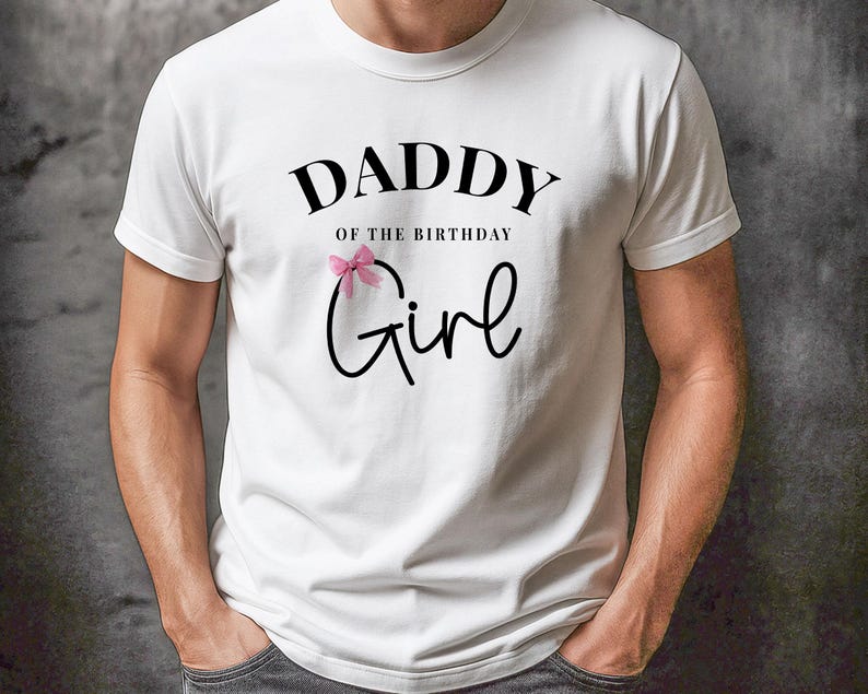 May include: White t-shirt with the text "DADDY of the BIRTHDAY Girl" in black script. A pink bow is above the word "Girl". The shirt is a crew neck and has short sleeves.