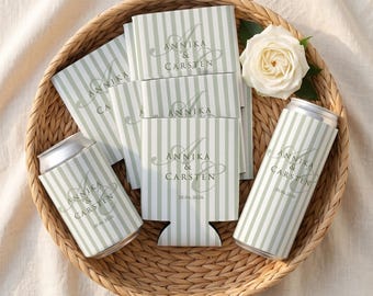 Puede incluir: Un conjunto de fundas para latas y tarjetas a rayas verde claro y blanco con el texto Annika & Carsten y la fecha 20.06.2026. Una rosa blanca individual se encuentra entre los artículos dentro de una cesta redonda de mimbre trenzado.
