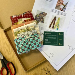 May include: A craft kit for making fabric straps. The kit includes a variety of patterned fabric scraps, a spool of thread, scissors, pins, and instructions. The instructions include a diagram of how to create the straps.