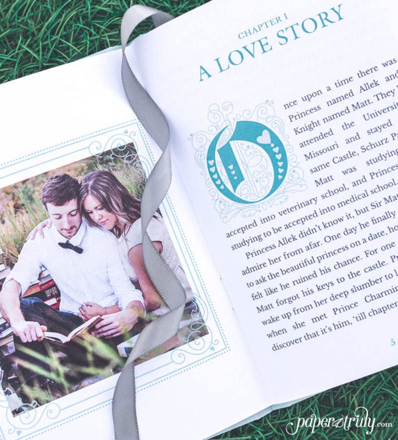 May include: An open book with a blue and white decorative design on the cover. The book is titled "A Love Story" and the first chapter is titled "Chapter I". A photo of a couple reading a book together is on the left page. The couple is sitting on a grassy surface.