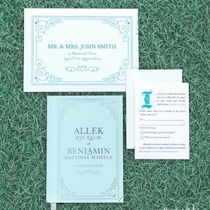 May include: A light blue wedding invitation with a decorative border. The invitation is for the wedding of Allek Lee Kelm and Benjamin Matthias Scheele. The text "A Tale of Love" is printed below the couple's names. The invitation includes a RSVP card with a whimsical design and the text "It won't be much fun without you now, will it? We are eager to hear from you! Kindly reply by the SECOND OF APRIL."