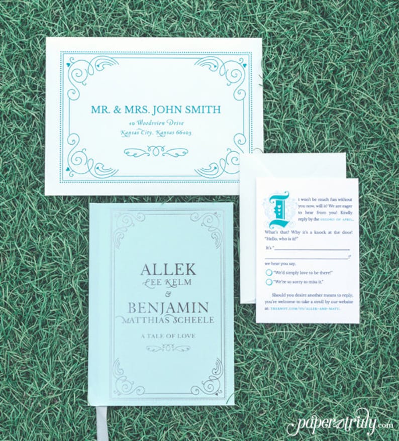 May include: A light blue wedding invitation with a decorative border. The invitation is for the wedding of Allek Lee Kelm and Benjamin Matthias Scheele. The text "A Tale of Love" is printed below the couple's names. The invitation includes a RSVP card with a whimsical design and the text "It won't be much fun without you now, will it? We are eager to hear from you! Kindly reply by the SECOND OF APRIL."