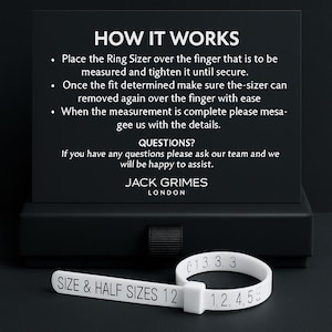 May include: A white ring sizer with black text reading "SIZE & HALF SIZES 12" and numbers. The sizer is next to a black card with instructions and the text "HOW IT WORKS" and "JACK GRIMES LONDON".