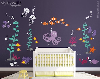 May include: A nursery wall decal set featuring an underwater scene with an octopus, jellyfish, seahorses, fish, seaweed, and bubbles. The decals are in various colors, including purple, orange, yellow, and green. The decals are shown on a purple wall with a white crib in the foreground.