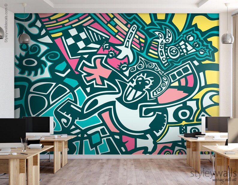 May include: Abstract wall mural featuring a teal, pink, yellow and white geometric design. The mural is in a modern office setting with two computers and desks.