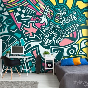 May include: A teal, pink, yellow and white abstract geometric pattern mural with a black and white chequered pattern. The mural is in a room with a desk, chair and a bed.