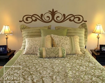 Puede incluir: Un edredón estampado en verde y blanco con una calcomanía decorativa de cabecera marrón. La cama está hecha con varias almohadas en varios tonos de verde y blanco.