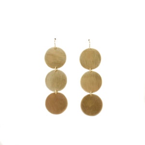 May include: Gold tone earrings with three round discs hanging from each earring.