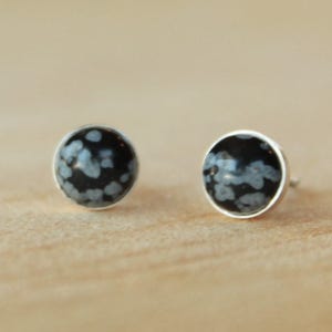May include: A pair of silver stud earrings with black and white snowflake obsidian stones.