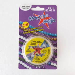 May include: Clear Stretch Magic bead and jewellery cord, .7mm diameter, 25 m. The purple package features the text "Stretch Magic" and "Bead & Jewellery Cord".