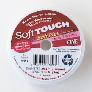 May include: A spool of Soft Touch Fine silver-colored beading wire. The label says "50% Softer and More Flexible" and "Premium Flex Wire". The spool is 30 feet long and has a diameter of 0.014 inches. It is made in the USA.