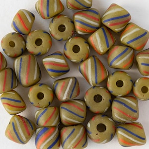 Peut inclure: Un assortiment de perles de verre vert olive, ornées de rayures rouges, blanches et bleues. Les perles, de formes variées (rondes, carrées), sont percées d'un trou central. Parfaites pour la création de bijoux, elles mesurent environ 1-2 cm de diamètre.