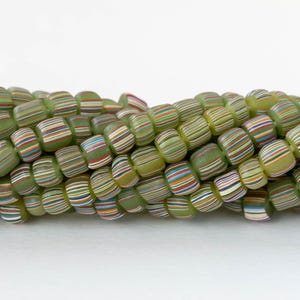 May include: Close-up of a strand of green glass beads. Each bead is a rounded rectangle with colorful horizontal stripes in shades of red, blue, orange, and white. The beads are strung together, creating a textured surface.