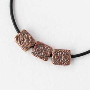 9,5 x 11 mm metallpärlor med blommotiv - antik koppar - 2, 6 eller 12 pärlor