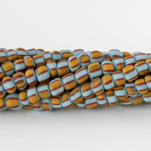Contas de vidro Java - Groselhas - Azul claro com listras amarelas e vermelhas - Fio inteiro ou meio fio