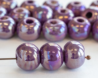 May include: A strand of iridescent purple ceramic beads, strung on a wire. The beads are round and have a glossy finish.
