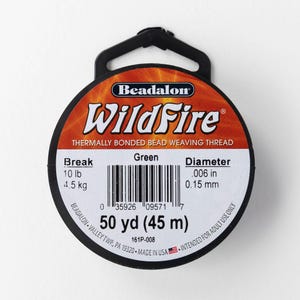 Może przedstawiać: Szpula zielonej nici WildFire termicznie łączonej do tkania koralików. Etykieta wskazuje wytrzymałość na zerwanie 4,5 kg i średnicę 0,15 mm. Szpula zawiera 45 m nici.