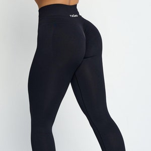May include: Black seamless leggings with the word "TRANA" printed on the waistband.