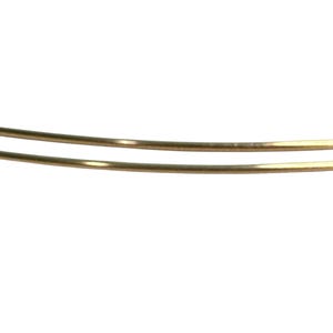 May include: Two thin, curved, gold-colored metal bangles are set against a white background. The bangles are parallel to each other and appear to be made of a smooth, shiny material. The image is a close-up.