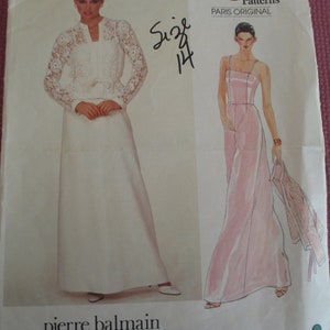 May include: Vogue Patterns Paris Original sewing pattern for a white lace top and a pink maxi dress. The pattern number is 2835 and the size is 14. The designer is Pierre Balmain.