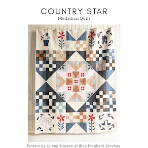 以下が含まれることがあります： 手作りの「カントリースター」メダリオンキルト。中央の星のデザインと、青、茶色、クリーム色の幾何学模様が特徴です。キルトのサイズは152cm x 190cmです。