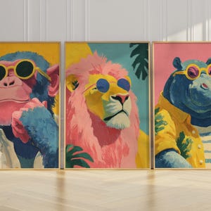 May include: Set of three framed art prints featuring anthropomorphic animals. A monkey, lion, and hippo are depicted wearing sunglasses and clothing. The artwork uses bright colors and a vintage style.