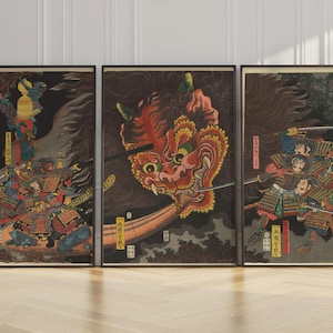 Könnte beinhalten: Set aus drei gerahmten japanischen Holzschnitten. Die Drucke zeigen Szenen von Samurai-Kriegern und einem großen, roten, feuerspeienden Drachen. Die Kunstwerke weisen lebendige Farben und komplizierte Details mit japanischen Schriftzeichen auf. Die Rahmen sind schwarz.