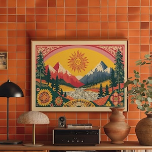 May include: A framed landscape art print with a retro design. The artwork features a smiling sun, mountains, trees, and a rainbow. The colour palette includes yellow, red, blue, and green. The print is displayed on an orange tiled wall.