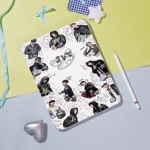 May include: White tablet case featuring a collage of images of people in various outfits, with the text "SVT" and other doodles. A white stylus is placed on the side. The case is on a light blue surface.