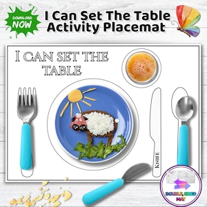May include: A rectangular activity placemat titled I Can Set The Table with outlines for a fork, knife, and spoon. The mat features a blue plate with a sheep made of food, a glass of orange juice, and a colorful butterfly graphic in the corner.
