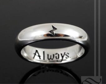 May include: A silver band ring inscribed with the word "Always" and a lightning bolt symbol on the top.