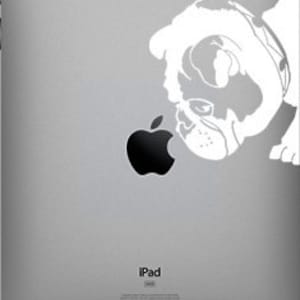 May include: White vinyl sticker of a French bulldog looking at an apple on a silver iPad.