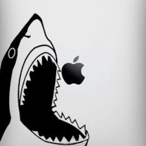 May include: A black and white sticker of a shark with its mouth open, biting into a red apple with a white leaf. The apple has a white outline and a black stem.