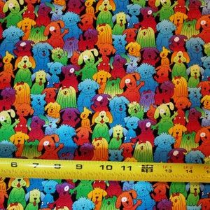 May include: A colorful fabric with a repeating pattern of cartoon dogs in various colors and poses. The fabric is black with a white measuring tape at the bottom.