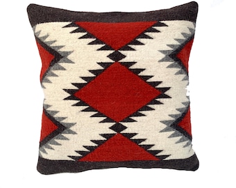 May include: A red, white, and black geometric patterned throw pillow. The pillow is made of a soft, woven fabric.