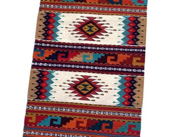 May include: A rectangular woven rug with a cream-colored fringe. The rug features geometric patterns in red, orange, teal, and brown. The central design includes diamond shapes and zigzags, creating a Southwestern style.