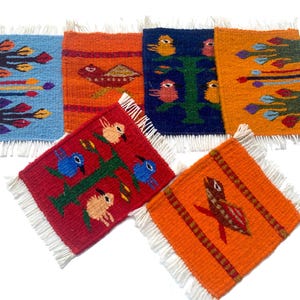 May include: A collection of six colorful, woven coasters with fringed edges. Each coaster features a unique design, including birds, trees, and abstract patterns in shades of blue, orange, red, and green. The coasters are square-shaped and appear to be handmade.