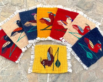 May include: Eight colorful woven coasters with fringed edges, each featuring a different bird design. The coasters are made of wool and have a variety of colors, including red, yellow, blue, and green.