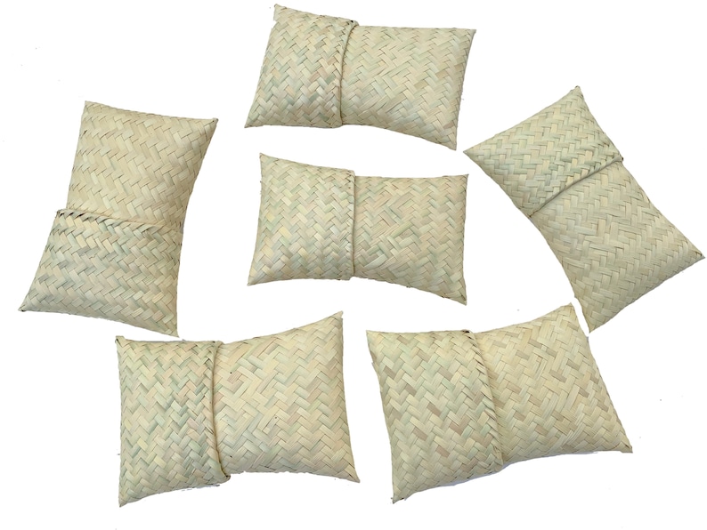 May include: Six woven straw pillows in a variety of sizes and shapes. The pillows are all a light beige color and have a woven pattern.
