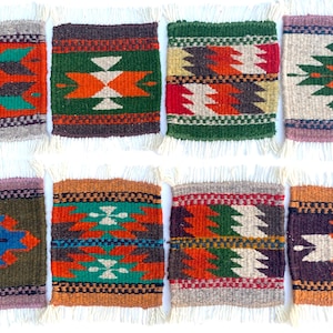 Pode incluir: Oito  costas de tecido coloridos com padrões geométricos em tons de vermelho, laranja, verde, azul, marrom e branco. Os  costas têm uma borda de franja.