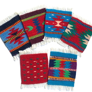 Puede incluir: Un conjunto de seis posavasos cuadrados tejidos con bordes con flecos. Cada posavasos presenta un patrón geométrico único en colores vibrantes como azul, rojo, verde y morado. Los posavasos miden aproximadamente 10 cm cuadrados.