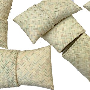 May include: A set of six woven straw pillows in various sizes and shapes. The pillows are made of natural, light brown straw and have a simple, rustic design.