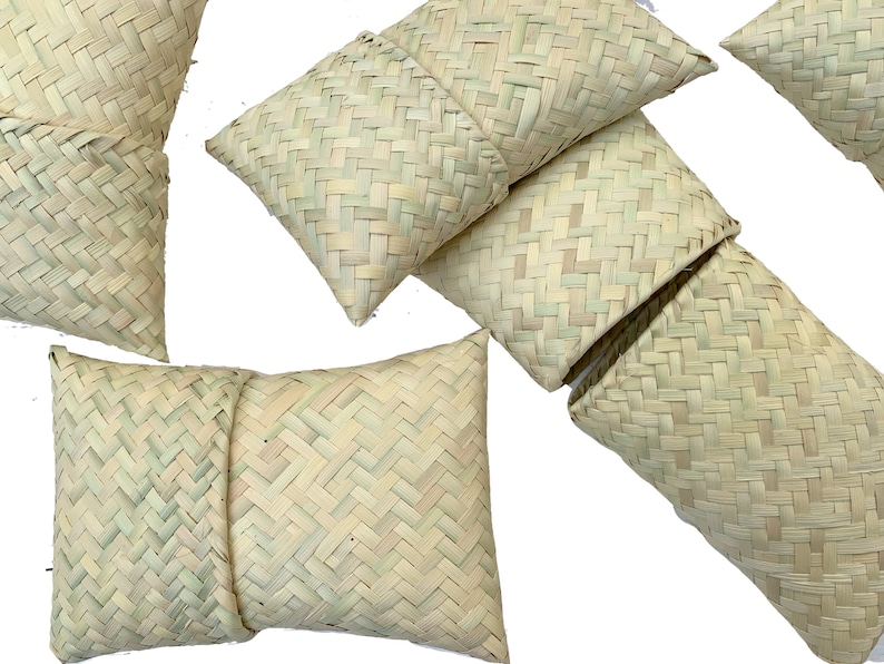 May include: A set of six woven straw pillows in various sizes and shapes. The pillows are made of natural, light brown straw and have a simple, rustic design.