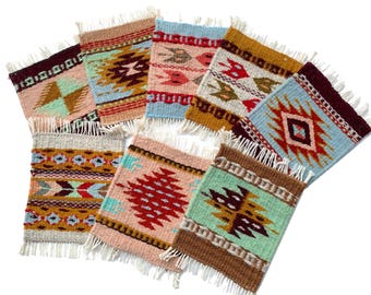 May include: A collection of nine woven coasters with fringed edges. Each coaster features a unique geometric pattern in various colors, including pink, blue, brown, and green. The designs showcase Southwestern-inspired motifs.