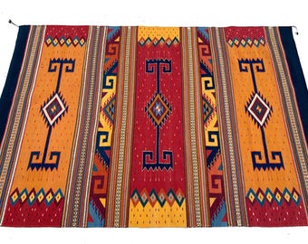 May include: A colorful woven rug with a geometric pattern in shades of red, orange, yellow, blue, and black. The rug has a traditional Southwestern design.